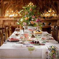 Decorative table setting with flowers, desserts, and glasses in a rustic dining room.
